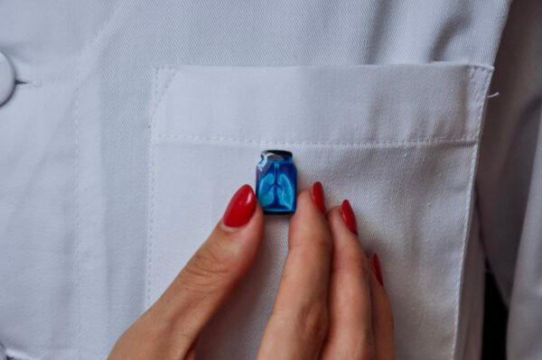 MedArtz Heart XL Pin being placed on a white coat.