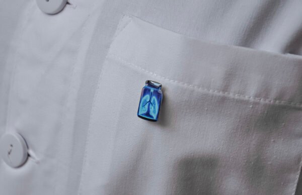 MedArtz Heart XL Pin on a white coat, lateral close view.