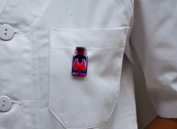 MedArtz Thyroid XL Pin on a white coat, front close view.