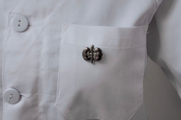 MedArtz Kidney Pin displayed on the pocket of a white lab coat.
